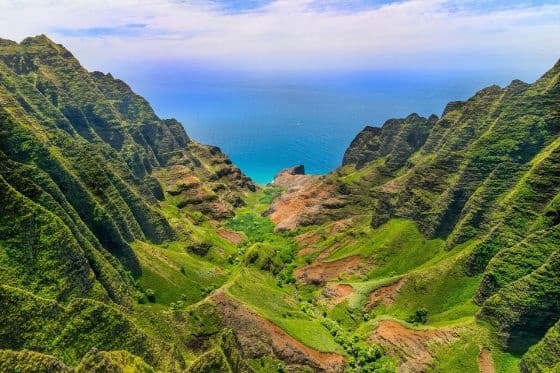 Aerial view of Na Pali Coast canyon and ocean cliffs, scenic Kauai