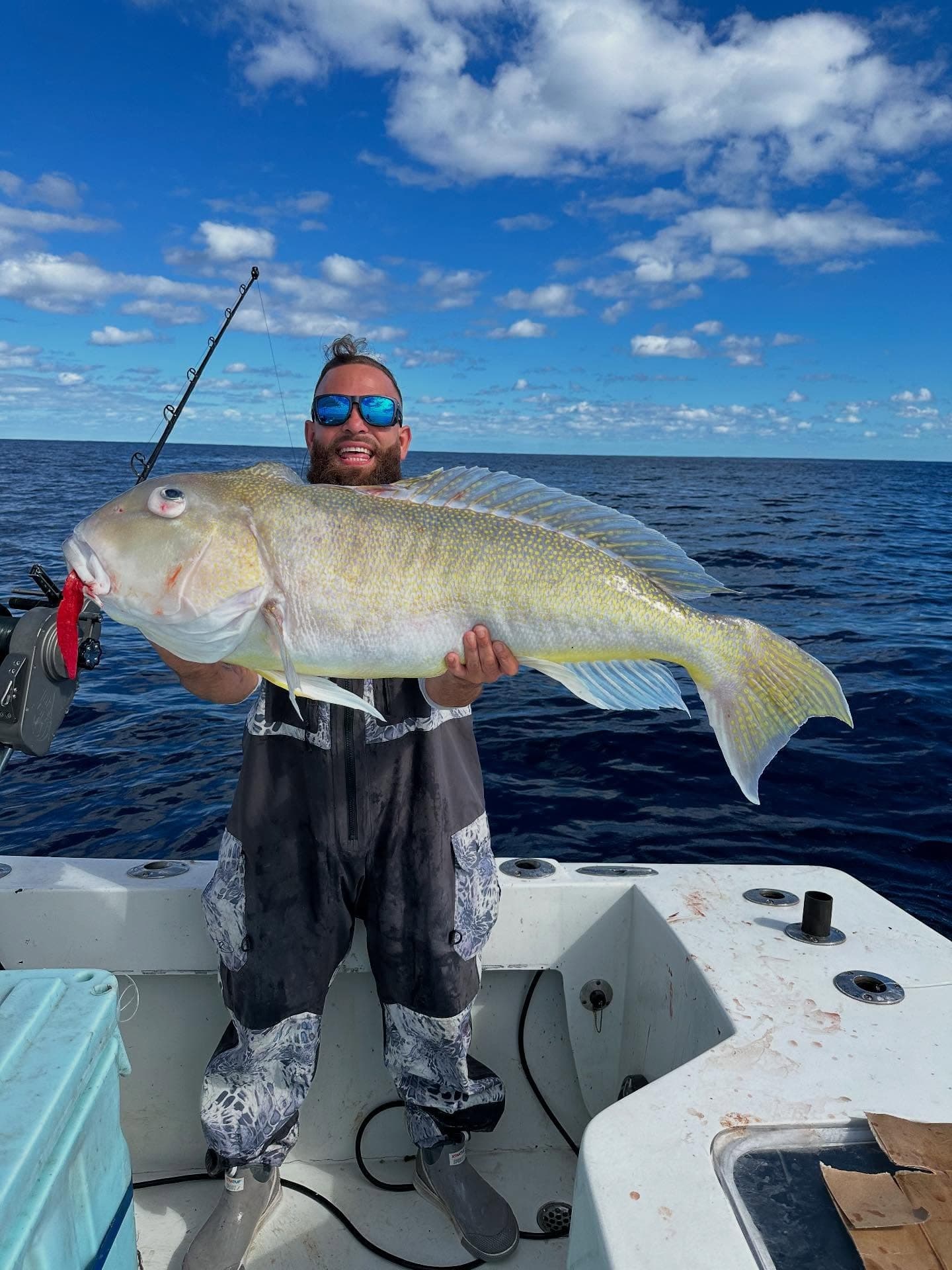 Fisherman holding a large yellowtail on offshore deep-sea charter