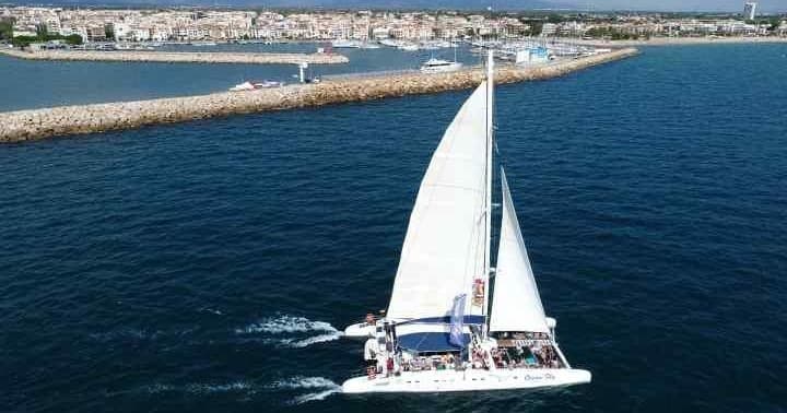 Sailboat cruising near harbor along sunny Catalonia coastline