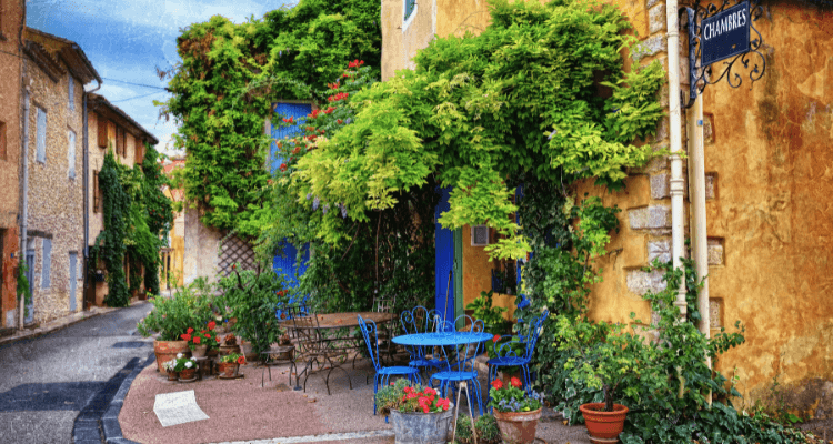 Charming sunlit European cobblestone street with outdoor cafés