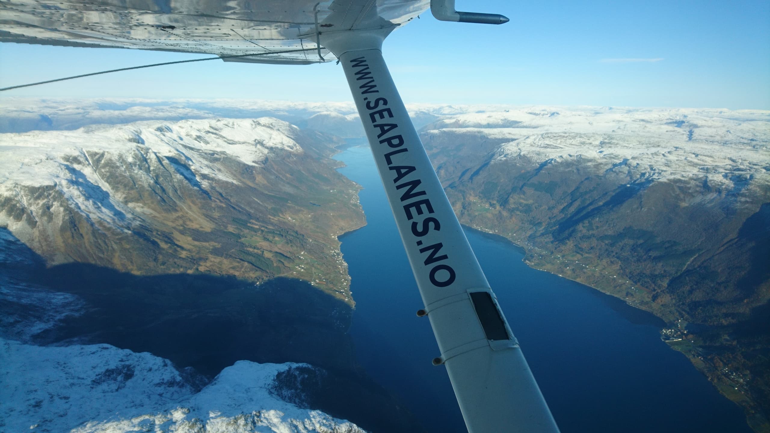 Aerial view from seaplane wing across steep Norwegian fjords