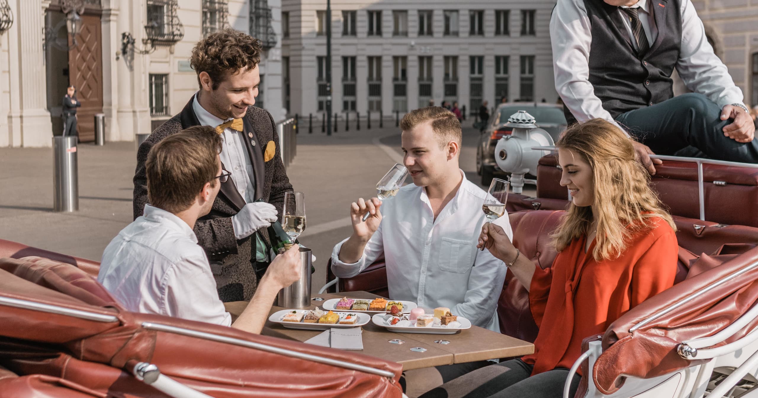 Group enjoying carriage dinner on cobbled city street, dining