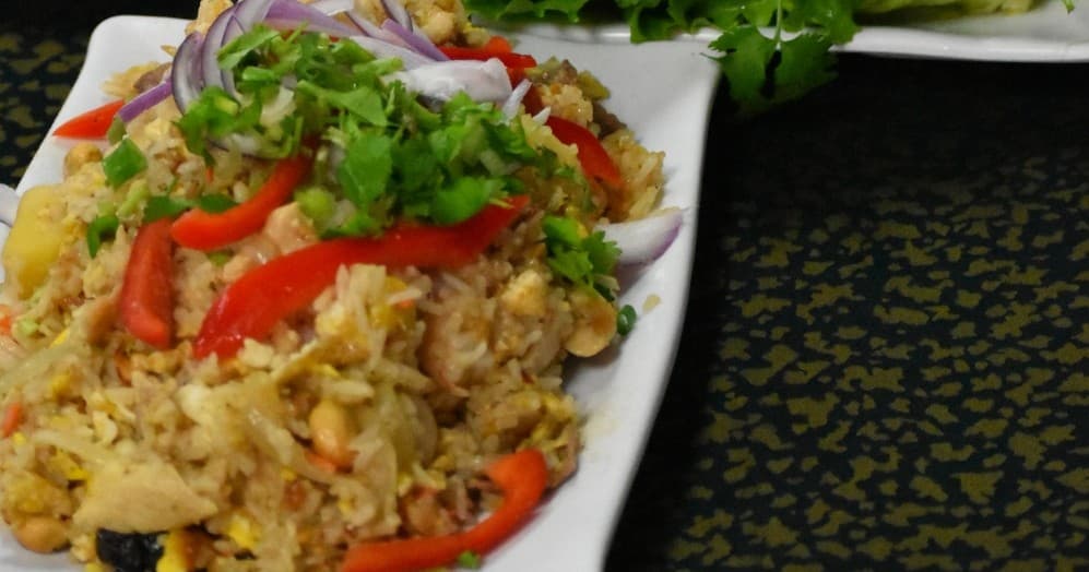 Chicken fried rice plated with peppers and cilantro at food stall