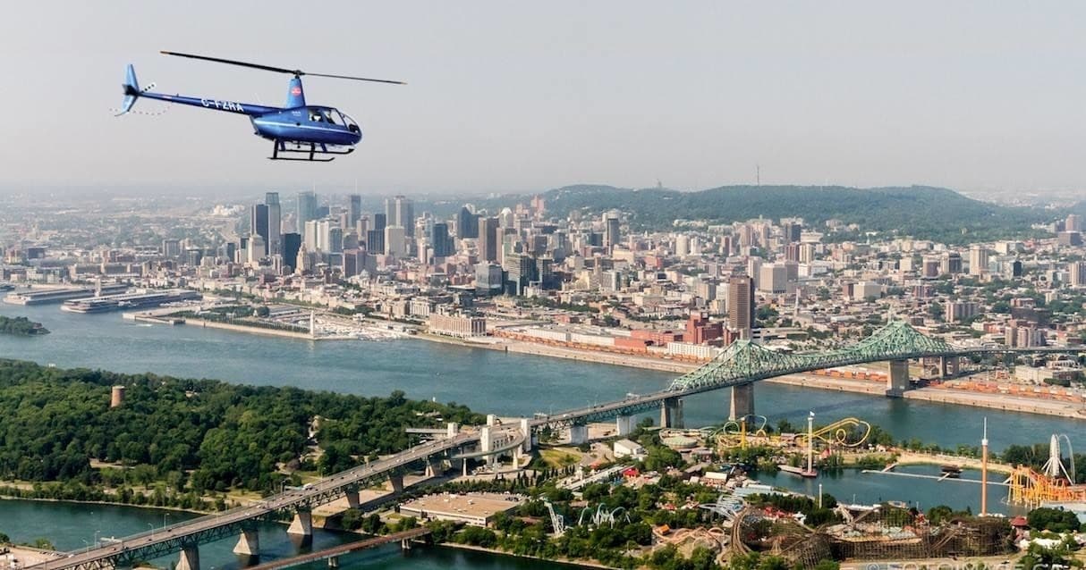 Helicopter flying above downtown city skyline over river
