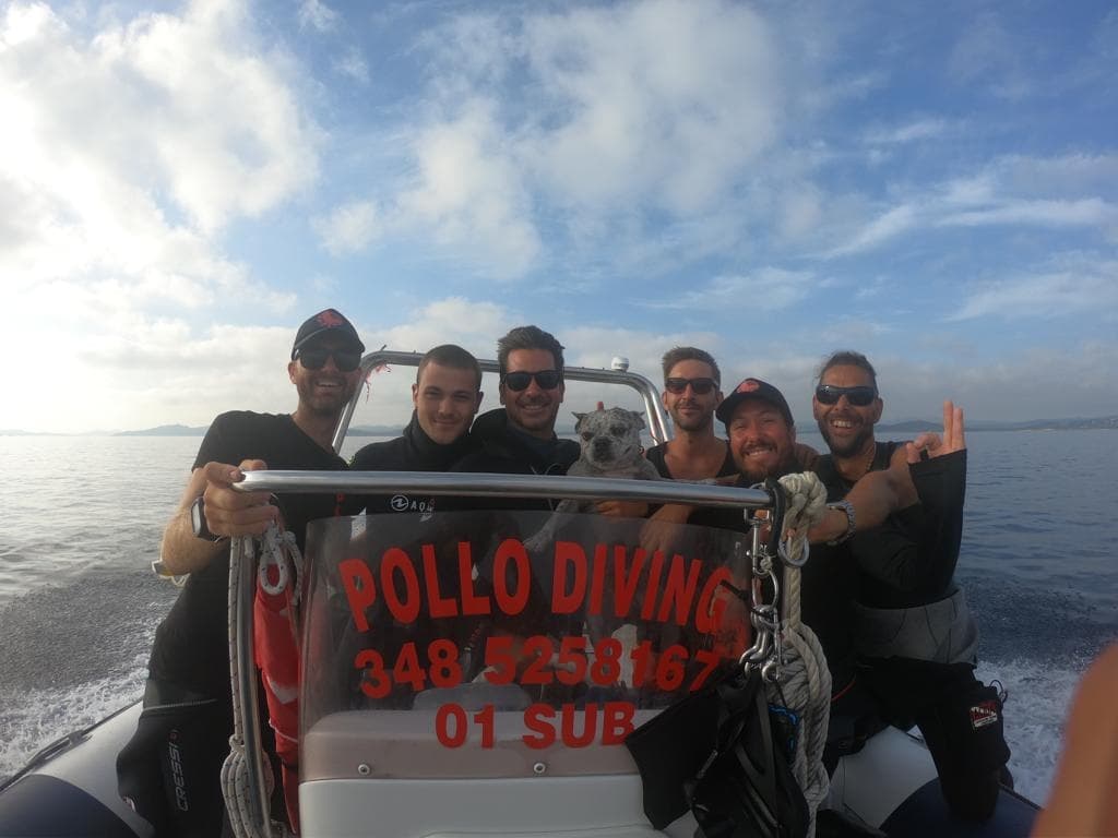 Diving crew on rigid inflatable boat holding Pollodiving banner