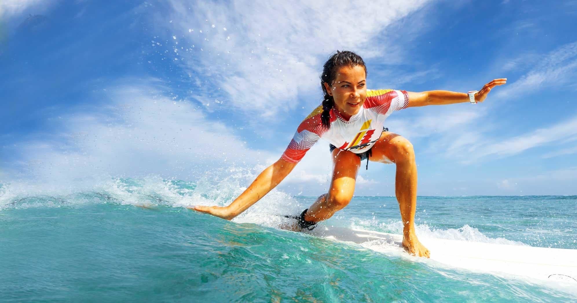 Surfer carving a wave on bright blue ocean during sunny session