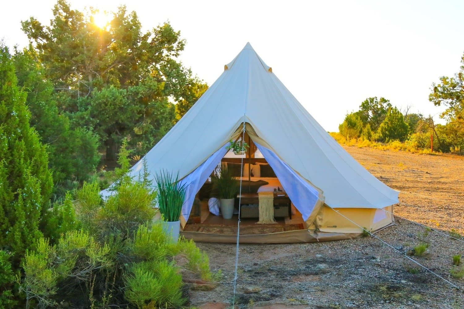 Glamping tent at sunset in scrubland offering backcountry camping