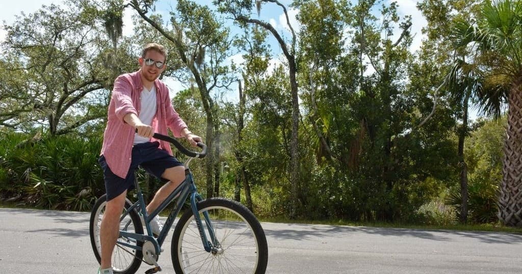 Cyclist riding on scenic island road through palms