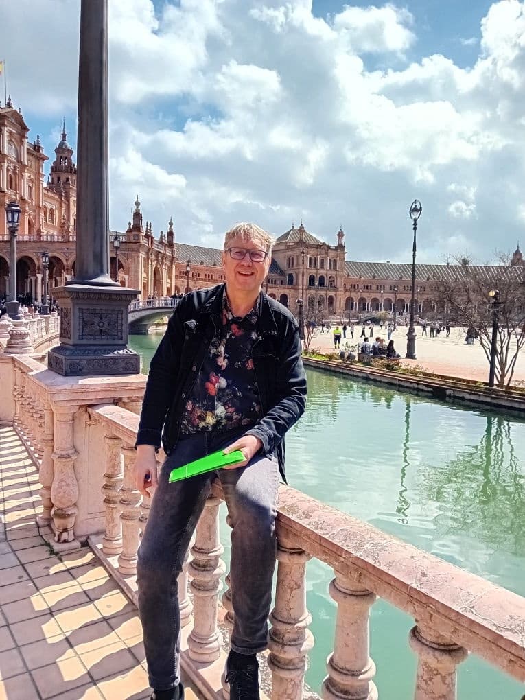 Traveler resting by the canal at Plaza de España during bike tour, Seville