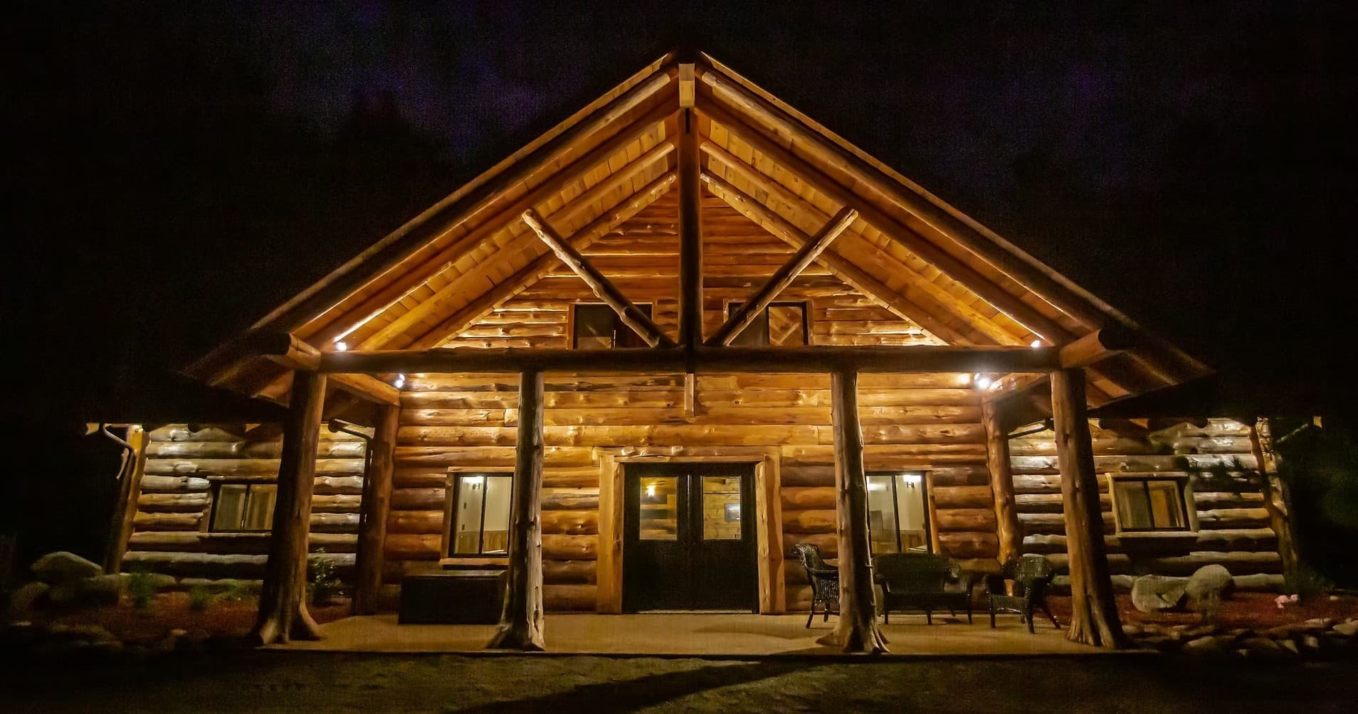 Rustic mountain cabin lit at night in wooded outdoor camp