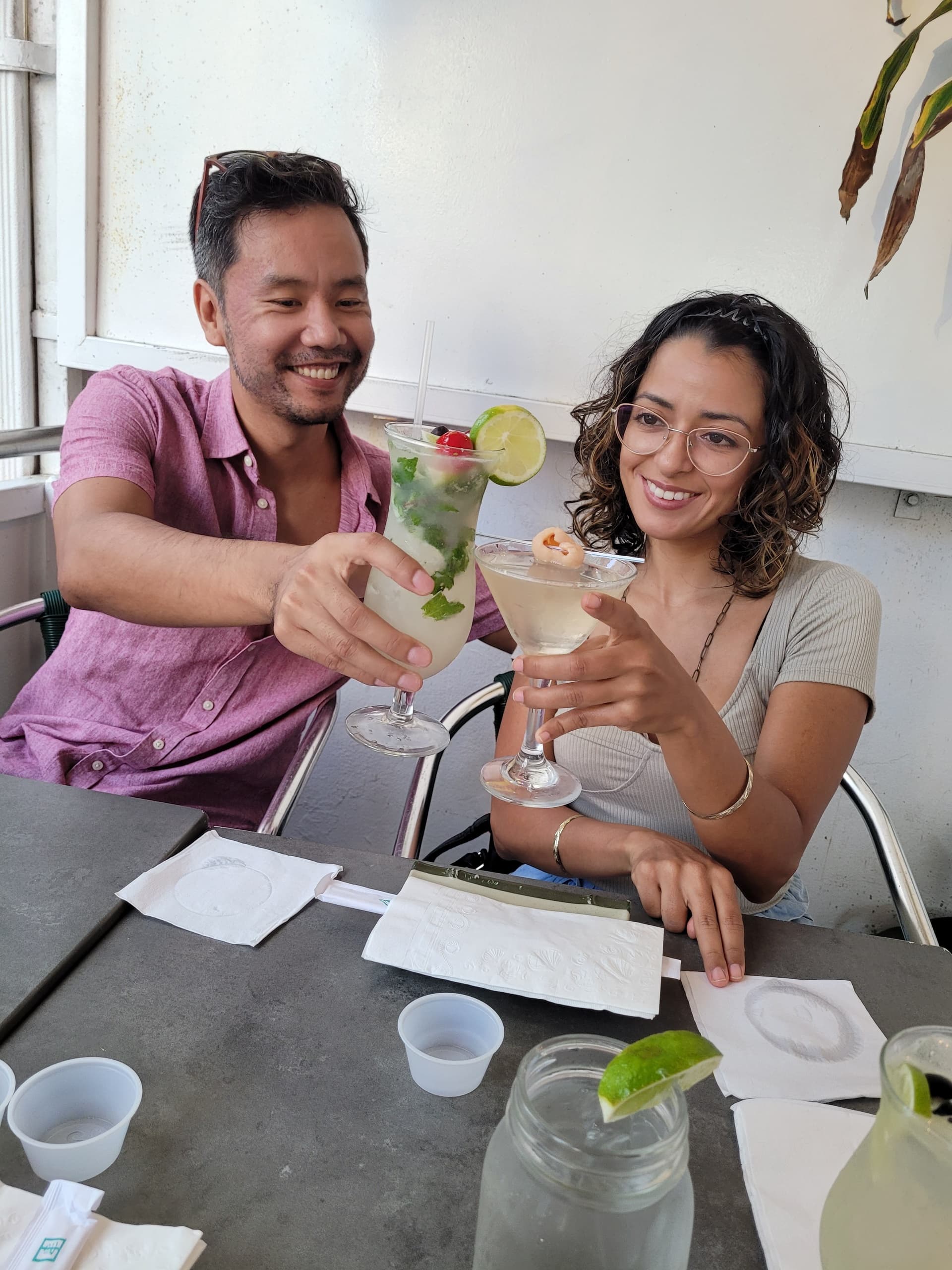 Couple clinking cocktails on outdoor restaurant patio in San Juan
