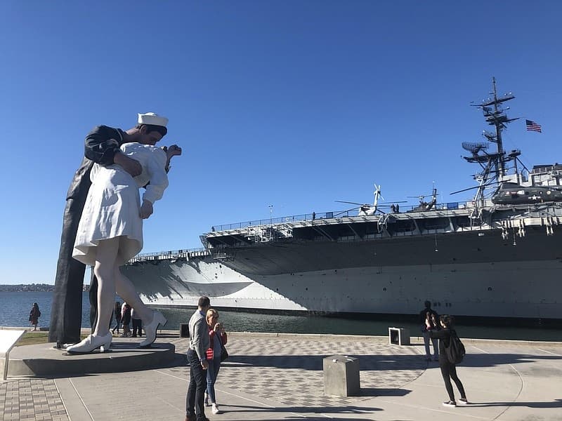 Kissing sailor statue and USS carrier at San Diego harbor view