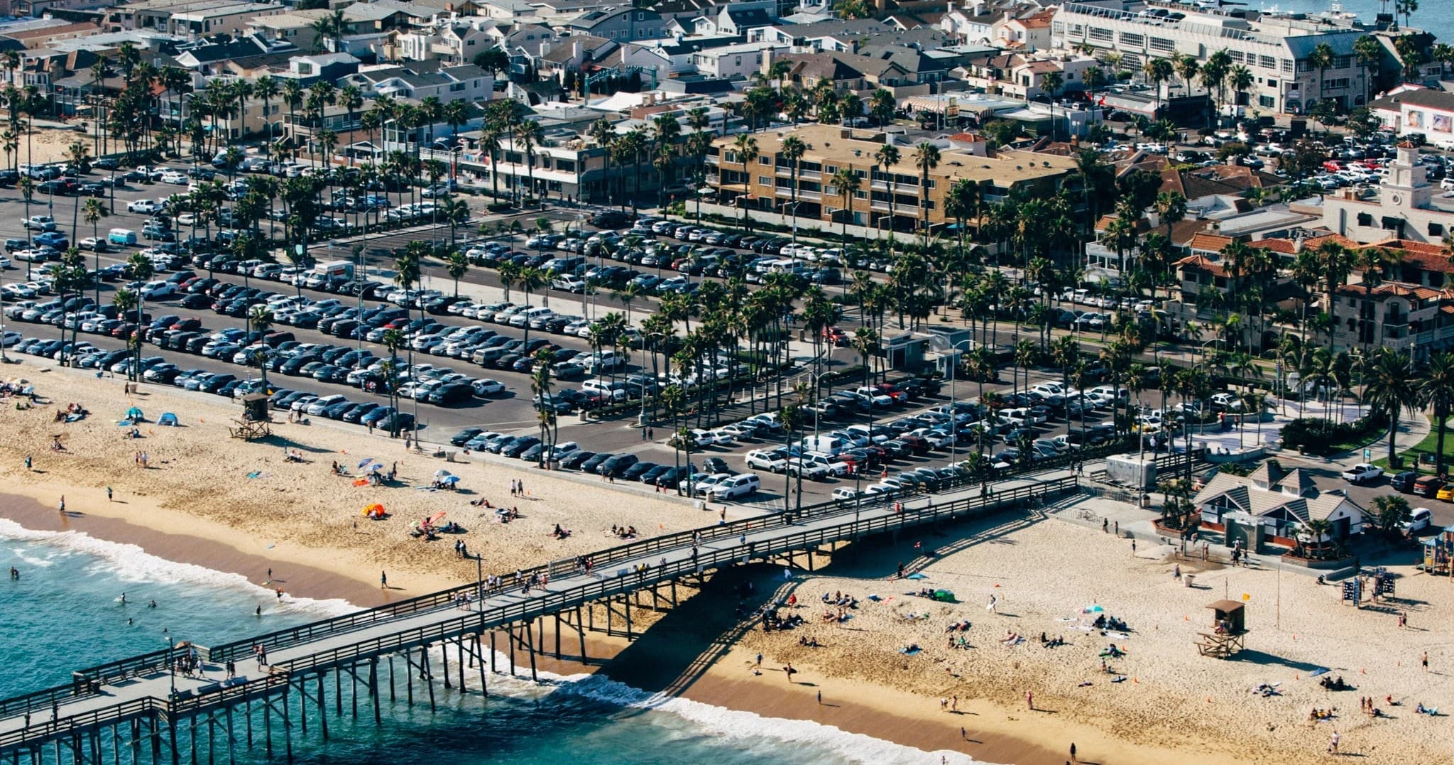 Aerial helicopter tour over sandy pier and beach in Southern California