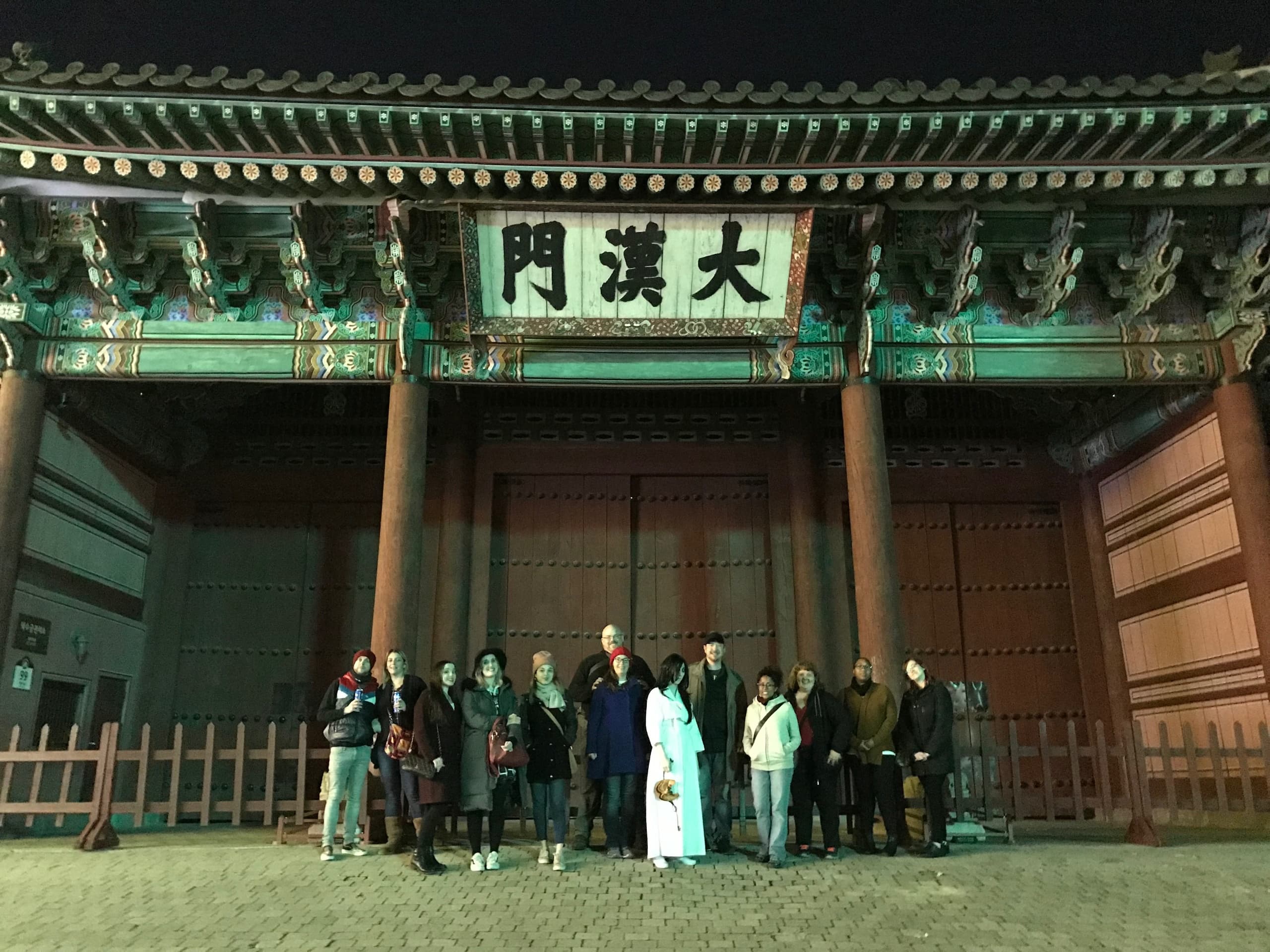 Traditional city gate illuminated at night with tour group