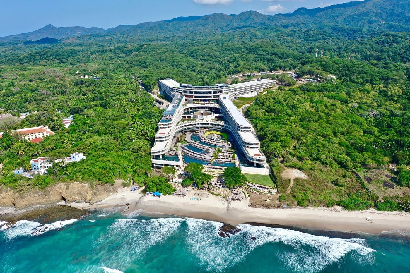 Aerial coastline resort with dramatic cliffs and surf, beach
