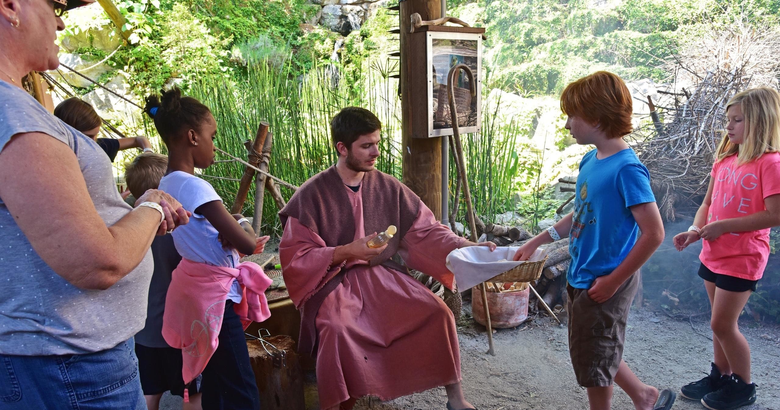 Interpreter in period costume engaging children outdoors at exhibit