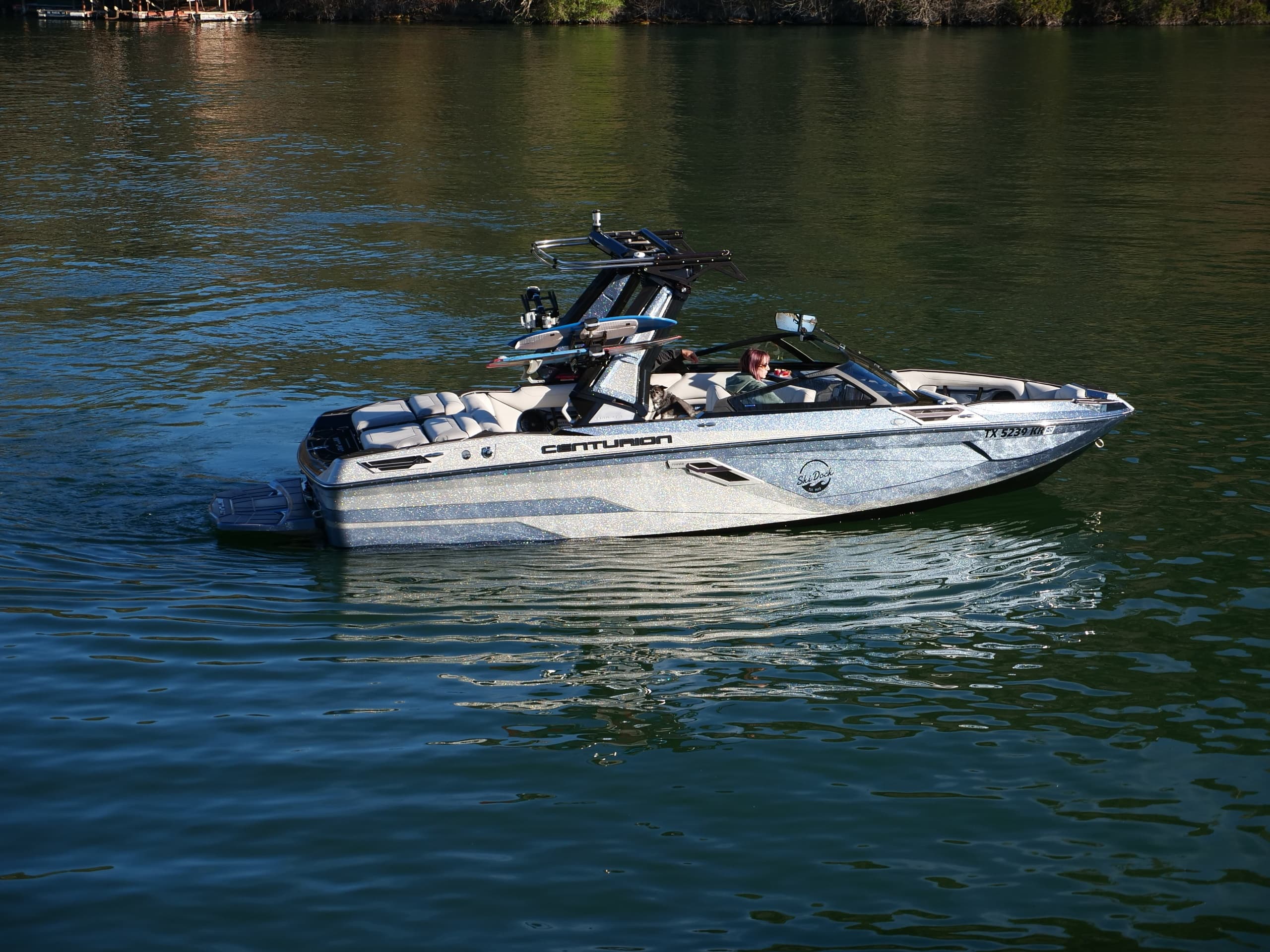 Performance wake boat cutting through calm lake water at speed