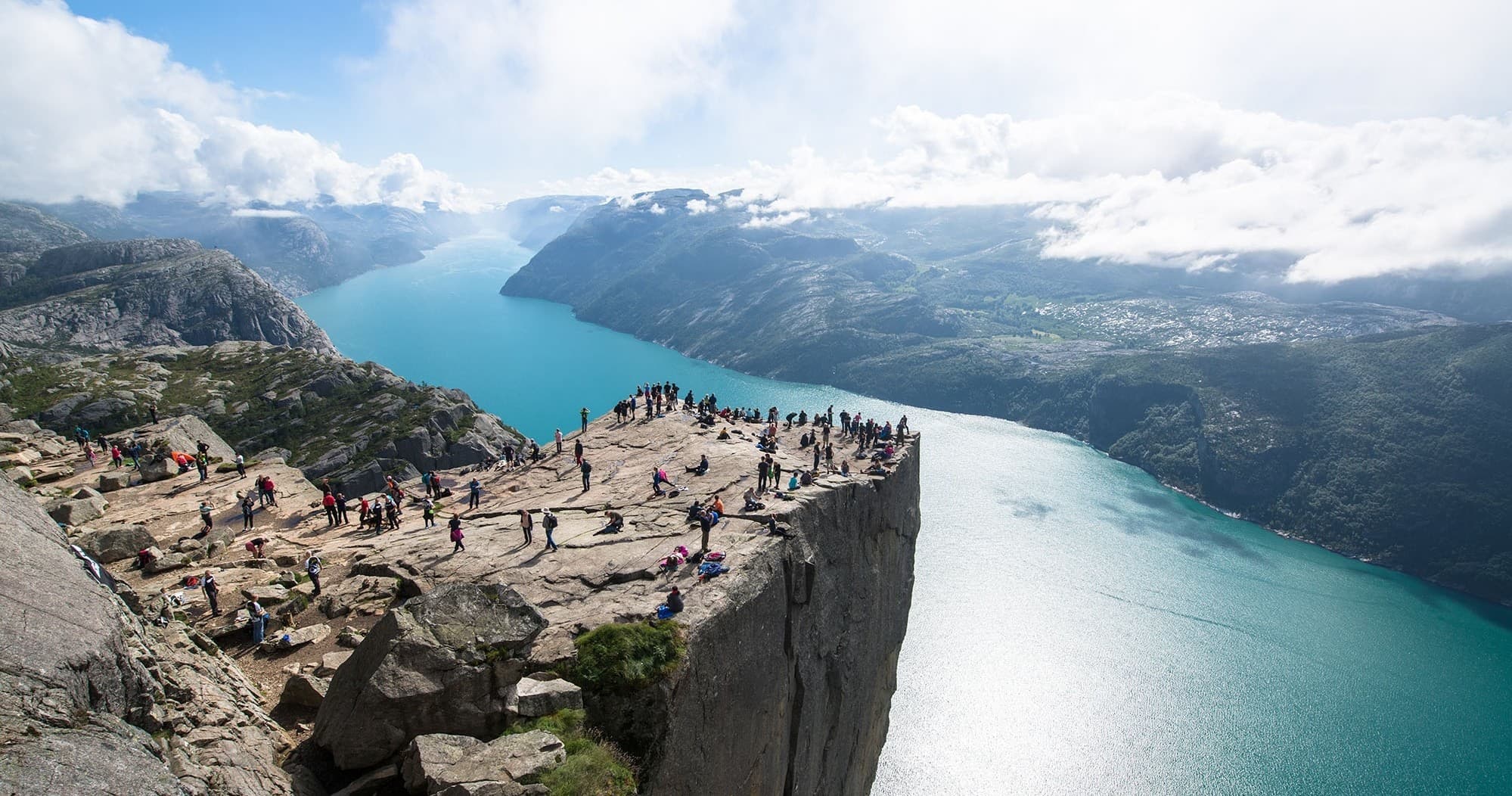 Visitors on Preikestolen cliff overlooking Norwegian fjord panorama