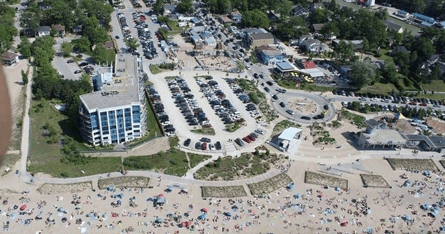 Aerial view of crowded beach, waterfront park and parking lots