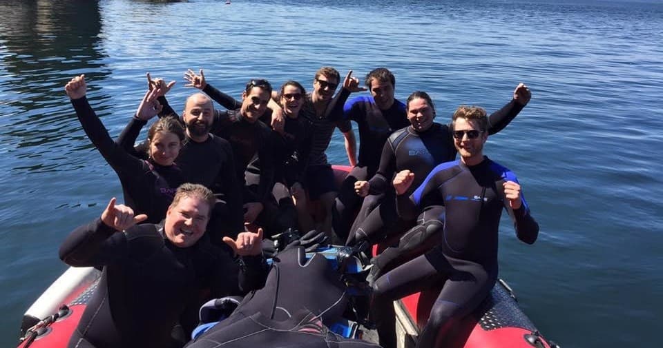 Group of divers on zodiac boat gearing up for ocean dive excursion