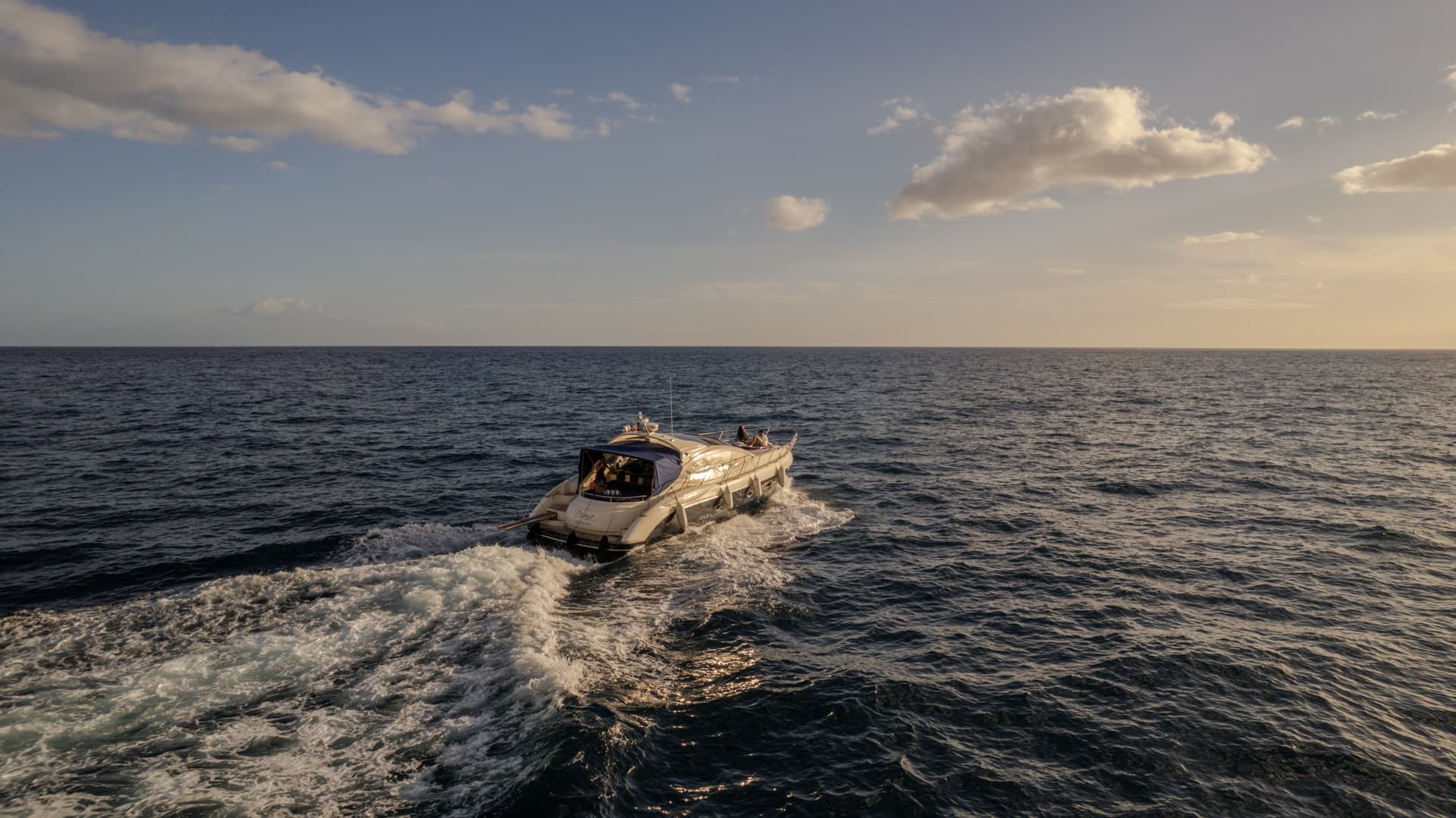 Yacht cutting through open sea off Madeira coast during calm late afternoon