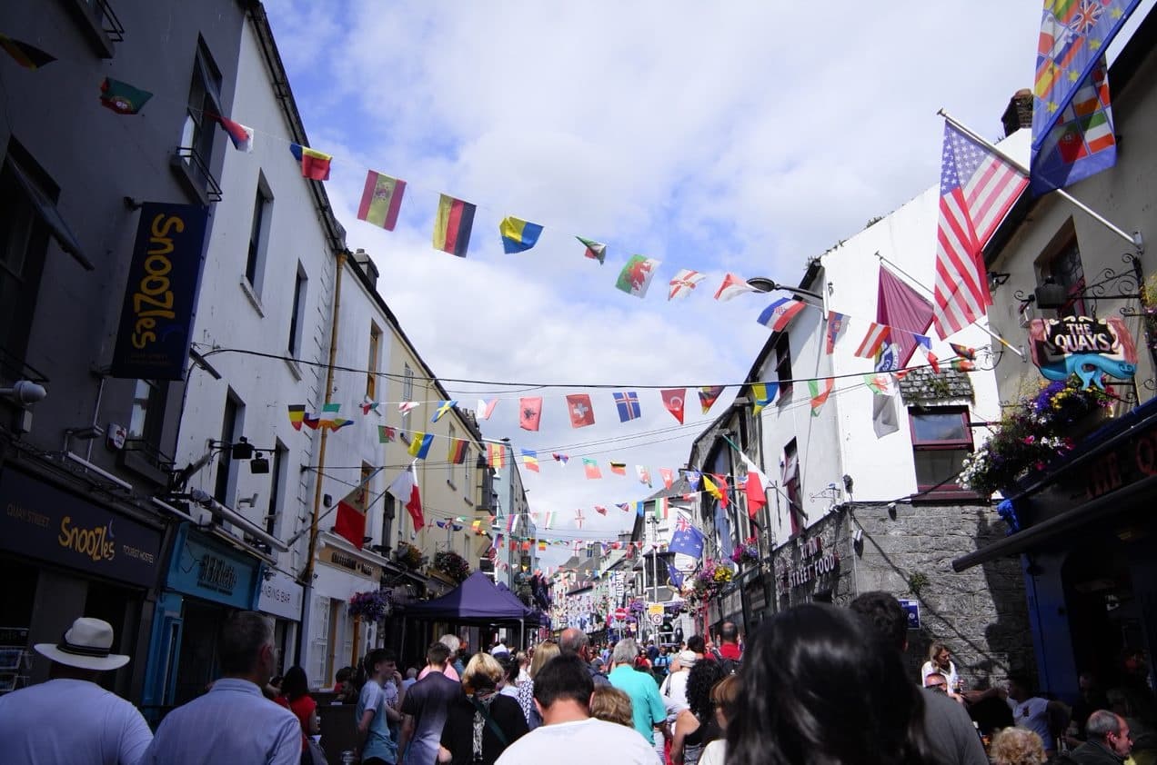 Crowded festival street with flags and outdoor cultural celebration