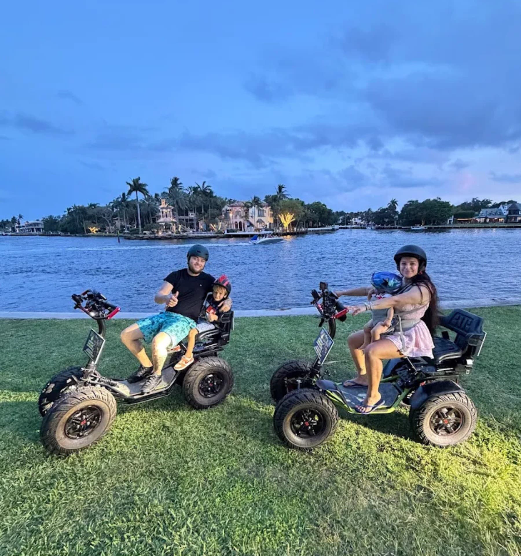 Two riders on electric trikes at Fort Lauderdale waterfront dusk