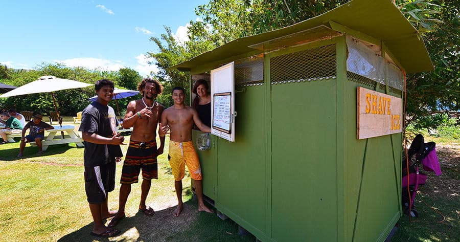 Outdoor snack shack with staff and visitors on grassy park