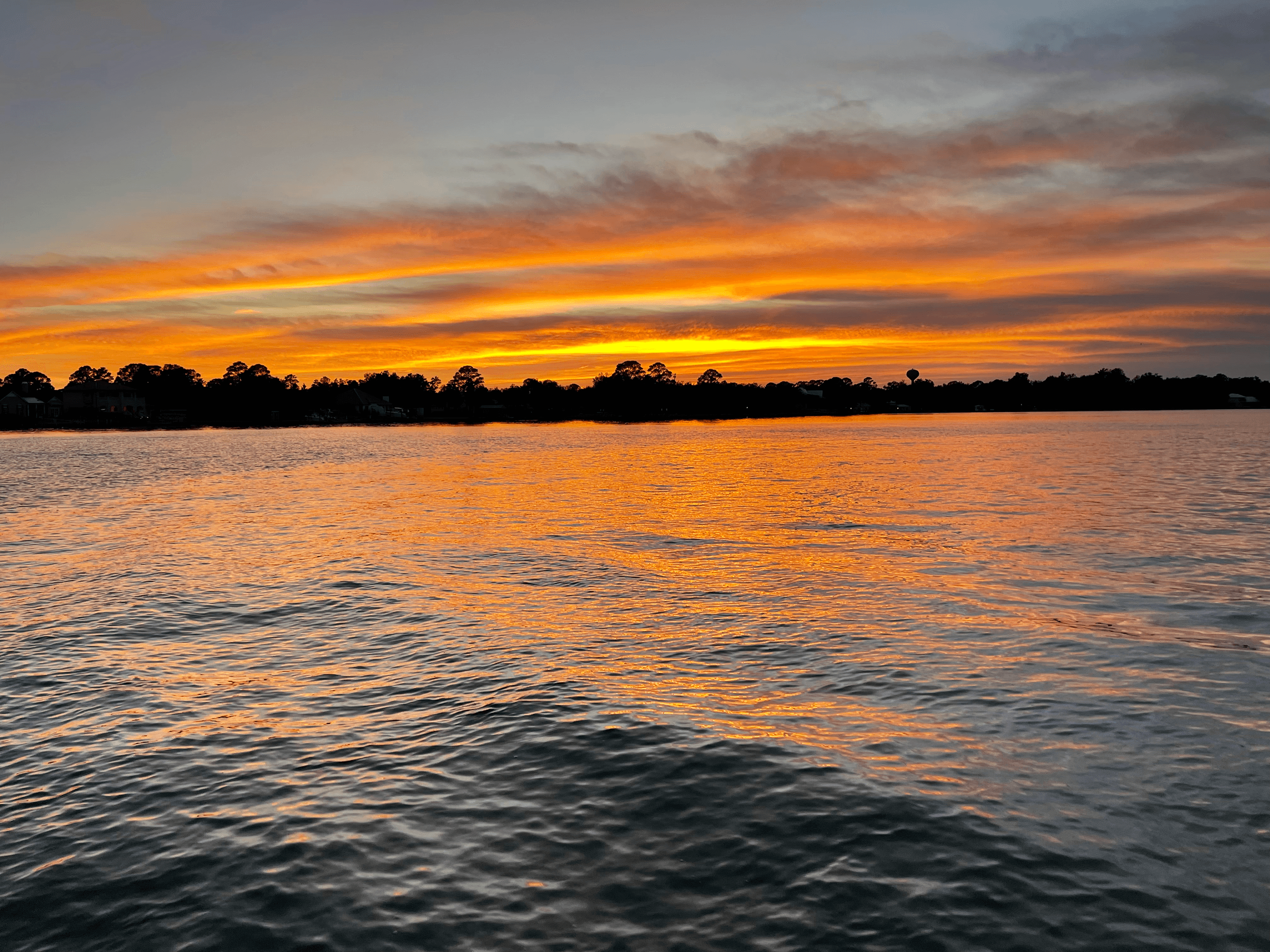 Sunset over coastal bay waters showcasing scenic charter views