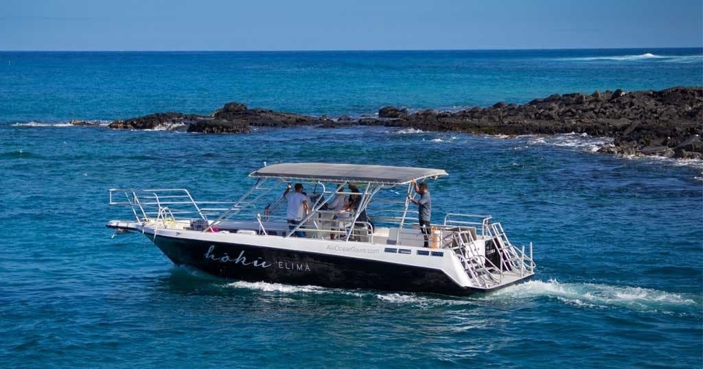 Tour boat cruising clear Pacific ocean near volcanic coastline