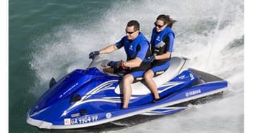 Two riders jet skiing on open lake waters, high-speed thrill