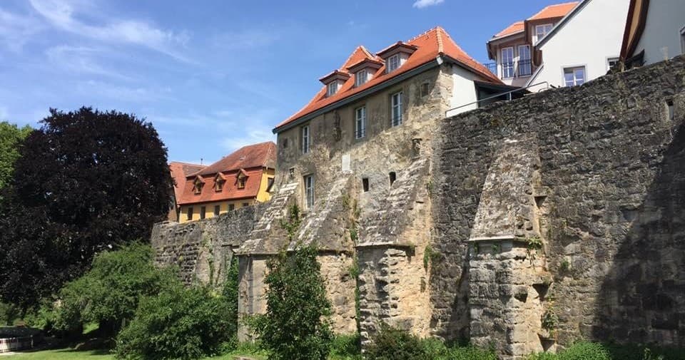Historic Bavarian town stone wall with riverside greenery