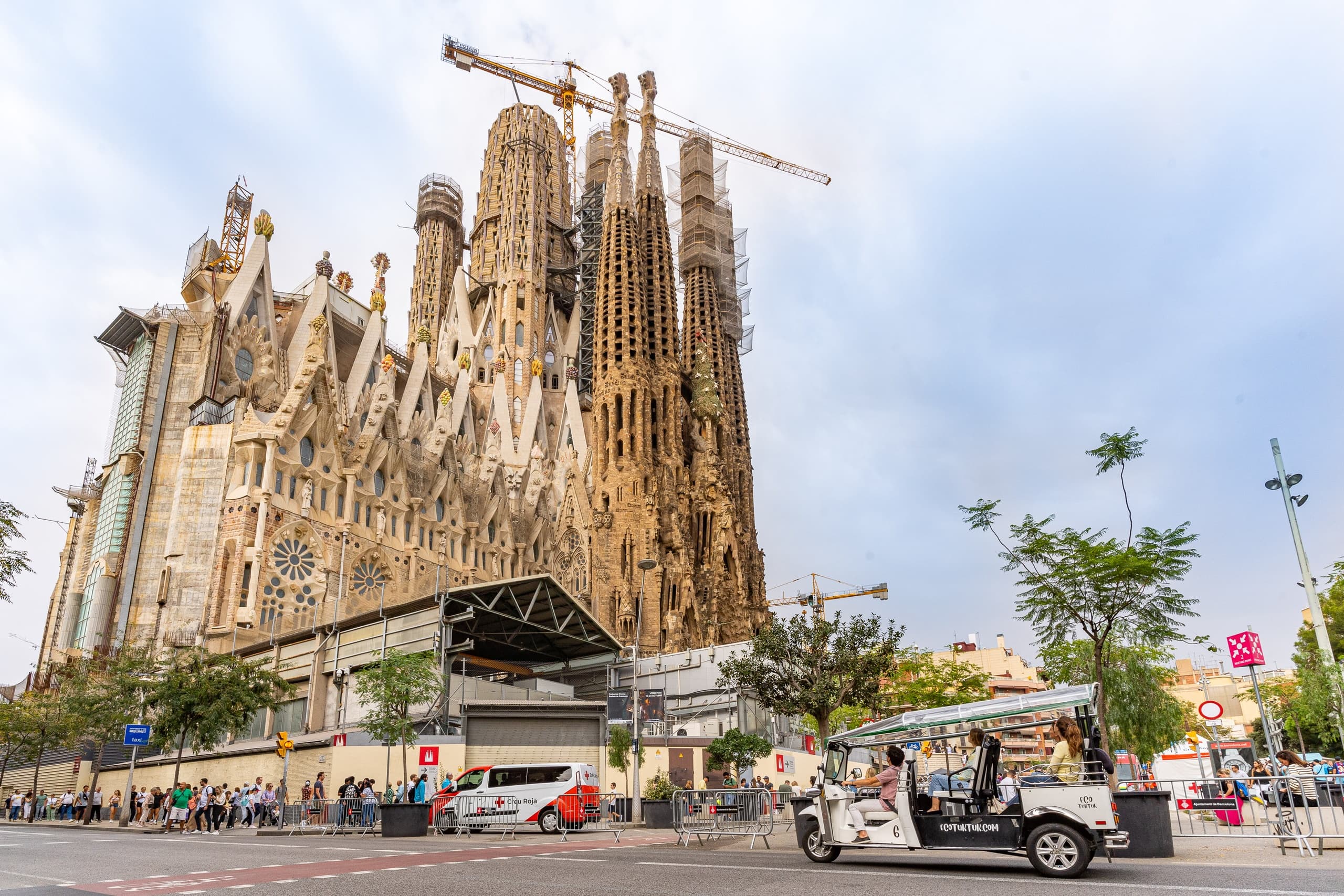 Sagrada Familia wide view with electric tuk-tuk tour in front