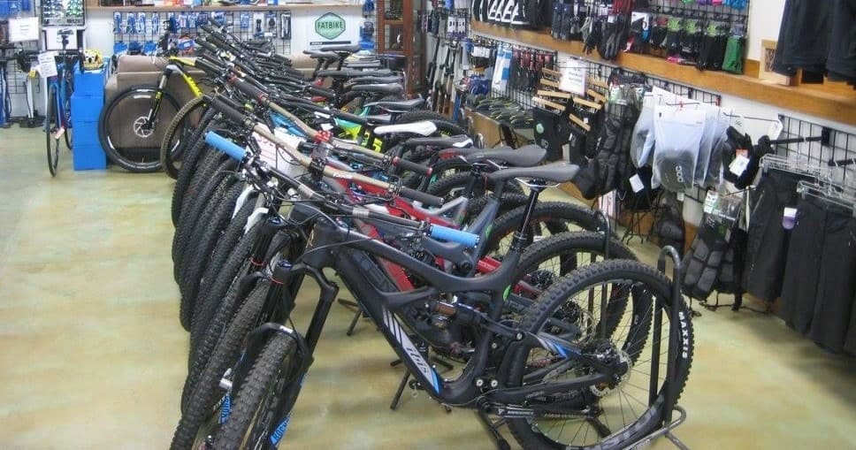 Row of mountain bikes lined up inside Alpine Bike Works shop