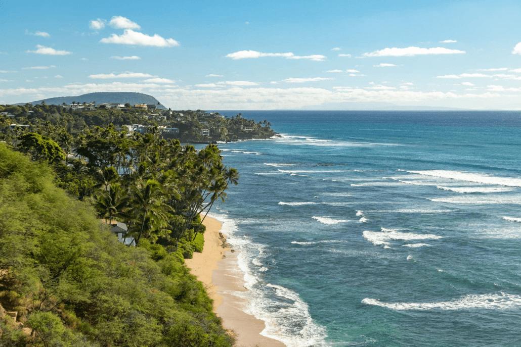 Aerial view of rocky coastline and blue ocean at sunset