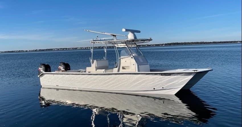 Center console boat anchored in calm bay, scenic offshore fishing