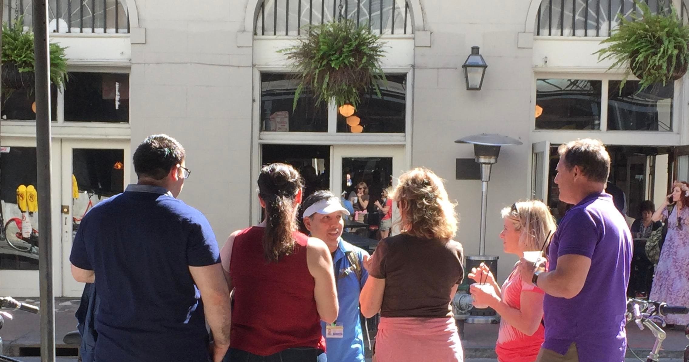 Walking tour group listening to guide outside historic French Quarter