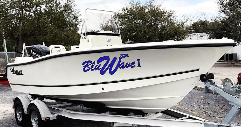 Center-console fishing boat on trailer near marina