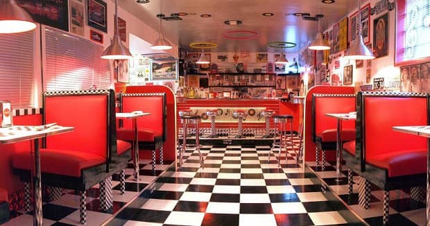 Dining in retro diner with red booths and checkered floor