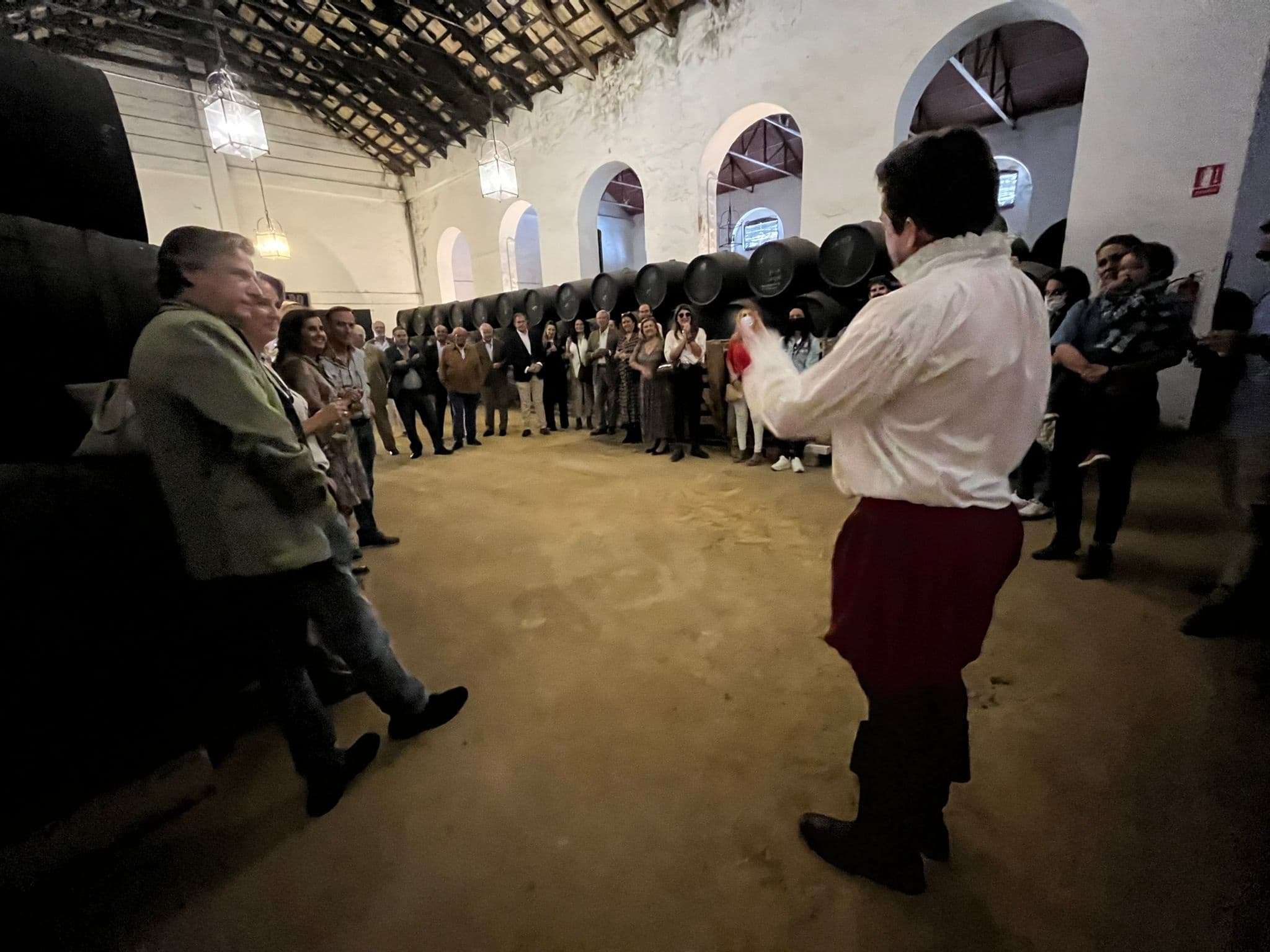 Guided winery tour inside historic barrel room with guests