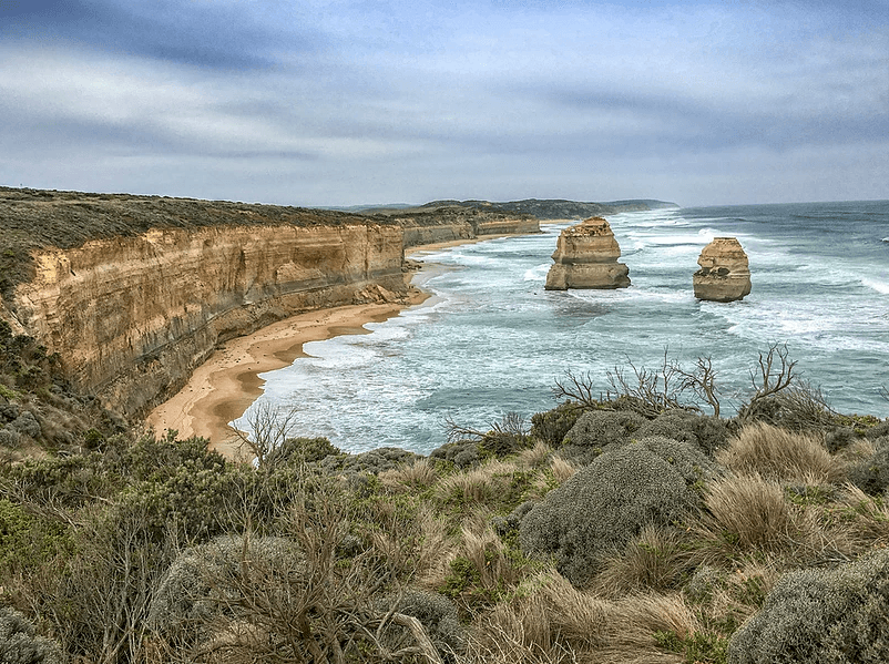 Scenic coastal cliffs and rock stacks along rugged shoreline vista