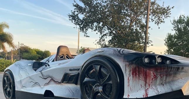 Custom painted amphibious car with dramatic red graphics parked by waterfront