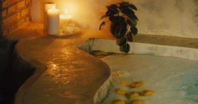 Candlelit indoor plunge pool with warm ambient spa lighting