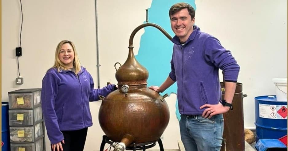 Distillers beside copper pot still inside Isle of Cumbrae distillery