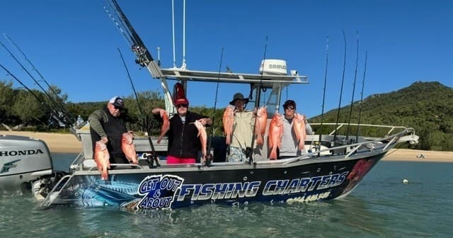 Group aboard fishing charter boat in Whitsundays near island