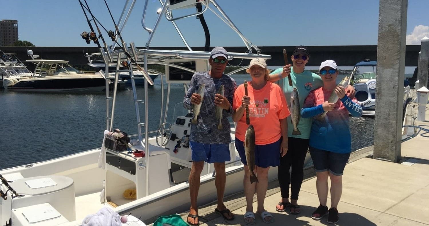 Group of anglers boarding charter boat at marina dock