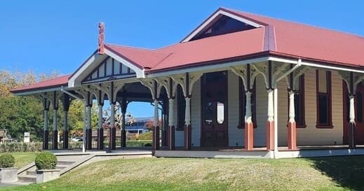 Visitors exploring historic lakeside station veranda in Rotorua park