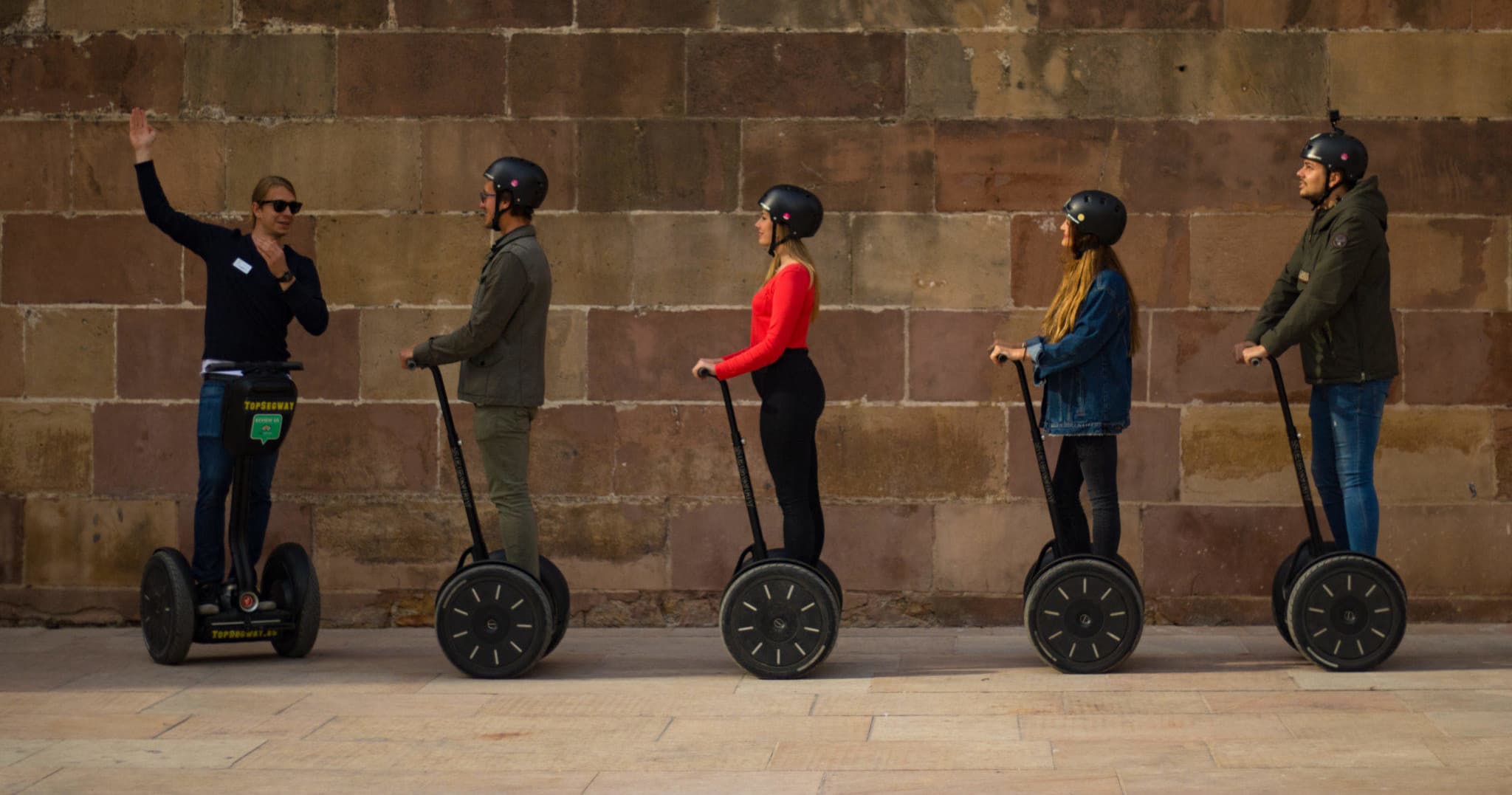 Line of Segway riders touring Malaga historic wall
