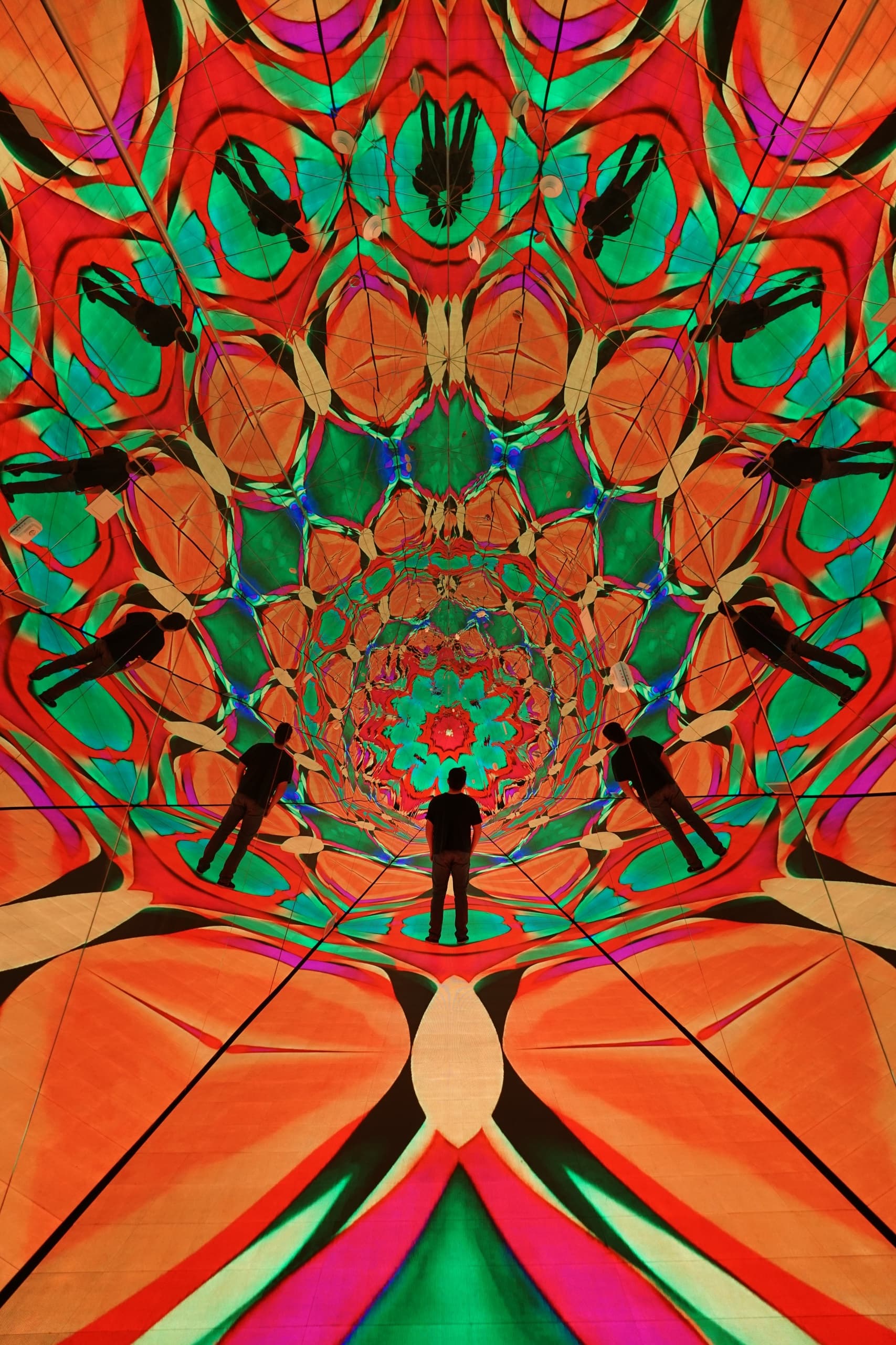 Visitor experiencing immersive psychedelic digital art installation in museum