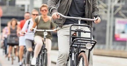 Group of cyclists on urban bike tour riding through city